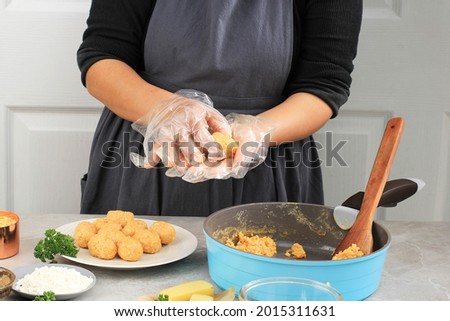 Female Hand Using Plastic Gloves Making Arancini, Rounding Rice Arancini. Cooking Step by Step in the Kitchen Royalty-Free Stock Photo #2015311631