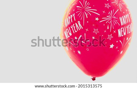 Close up isolated shot of Happy New Year text firework and star pattern decoration big red helium air fly circle shape rubber balloon in celebration party in front of white background with copy space.