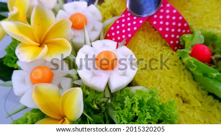 Indonesia yellow rice (called nasi kuning) for birthday celebration (called nasi tumpeng) with floral decorations.  Royalty-Free Stock Photo #2015320205