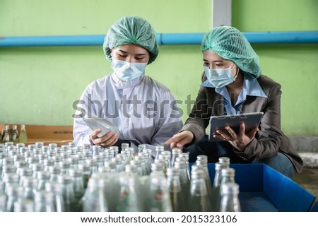 professional inspection control scientist in uniform are working for fruit juice production industry in food manufacturing factory, water drink checking and beverage research in laboratory