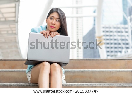 Beautiful cute girl in business woman clothes  using laptop computer , business urban city background