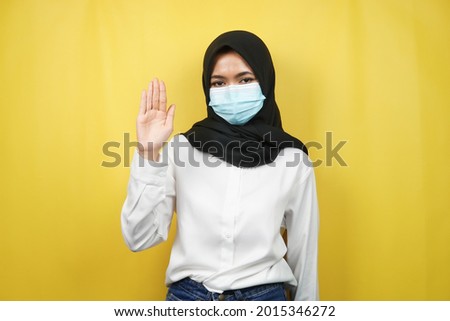 Muslim woman wearing medical mask with open hand sign, how are you doing, hello sign hand, isolated on yellow background