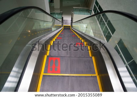 escalator empty inside building, in the event of a virus outbreak social distance sign