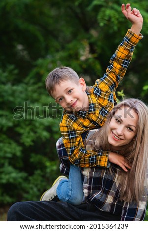 Happy family concept. Beautiful mother and son spending time together in backyard. Having fun. Enjoy summer vacation. Crazy mood