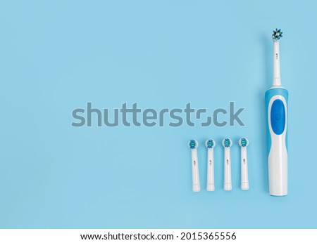 Modern electric toothbrush set with replacement heads on flat lay background. Concept of professional oral care and healthy teeth by using smart sonic toothbrush. Toothbrush with a Few Spare Heads