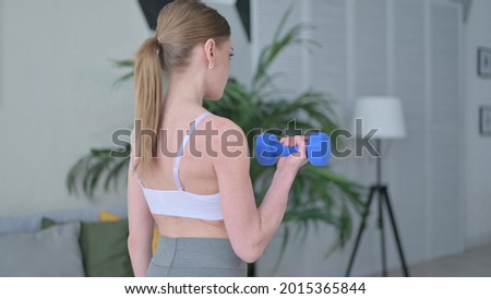 Back View of Woman doing Workout with Dumbbells at Home 