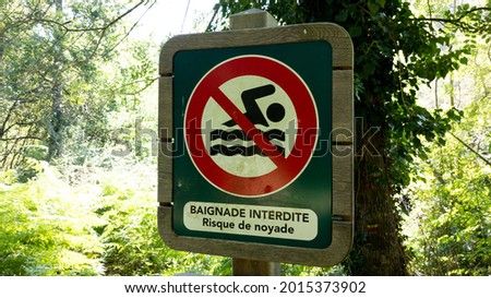 No bathing sign prohibited and risk of drowning text in french means baignade interdite risque de noyade on beach river