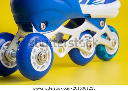 Blue skates shoes on yellow background

