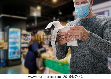 Male customer doing grocery shopping at supermarket and feeling confused by bill Royalty-Free Stock Photo #2015427443