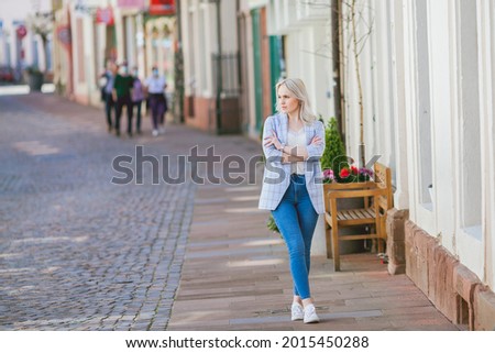 Portrait of a beautiful young woman in a European city. Makes purchases. Tourism.