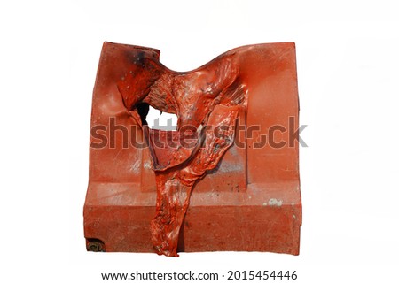 A red plastic block is badly burnt, melt and deformed by fire.  Caution for outdoor material storage.  Isolated on white background.