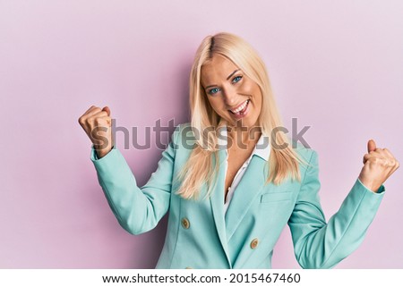 Young blonde woman wearing business clothes screaming proud, celebrating victory and success very excited with raised arms 