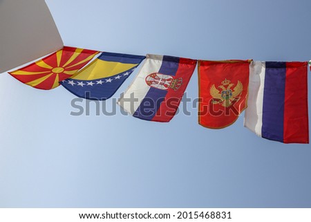 Flags of Balkan Countries And Russia Swaying Together Against The Blue Sky