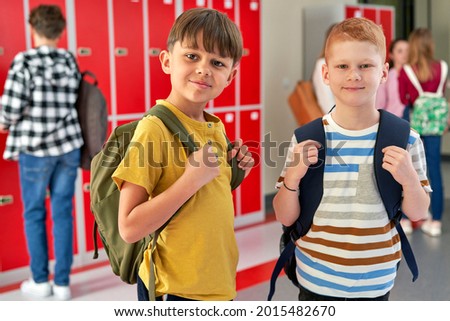 Portrait of schoolboys smiling and standing in the corridor                                