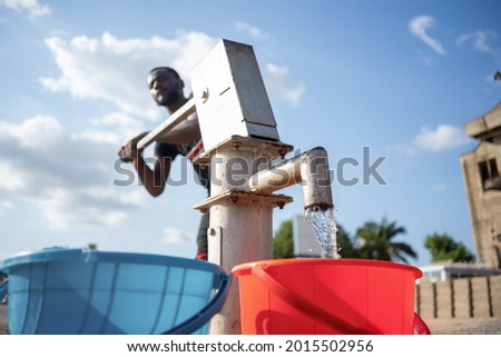 image of fresh water flowing from an African made borehole to bucket Royalty-Free Stock Photo #2015502956