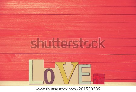 Little gift and word Love on wooden table.