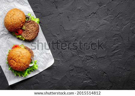 Burgers with beef meat steak on stone table, top view