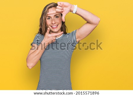 Young blonde woman wearing casual clothes smiling making frame with hands and fingers with happy face. creativity and photography concept. 