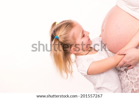 Happy child holding belly of pregnant woman isolated on white background