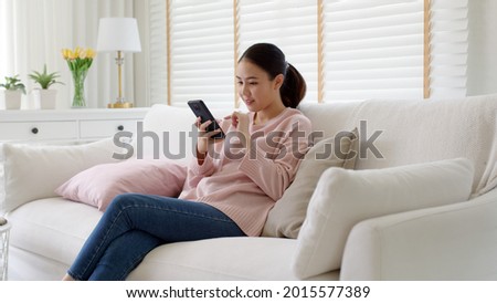 Young asia people 5G wifi digital device user teen girl watch read news play social media, e-commerce iot data app, pay money, remote shop retail store at home sofa couch sit easy relax happy smile. Royalty-Free Stock Photo #2015577389