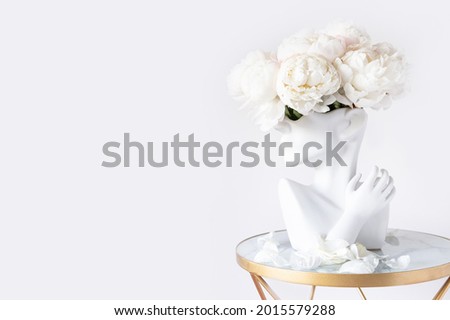 Fresh bunch of white peonies in vase in shape of womens face on light background. Trendy Ceramic Vase of human head, Handmade Modern Statue Art Flower Vase. Card Concept, copy space for text Royalty-Free Stock Photo #2015579288