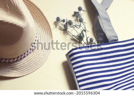 Sun hat, striped blue cotton bag and dry flowers. Flat lay composition summer women's accessories