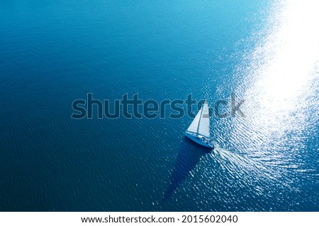 Aerial view of a white yacht with a sail. Ship in the blue sea Royalty-Free Stock Photo #2015602040