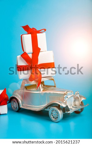 Silver car with gifts on a blue background. Buying a car.