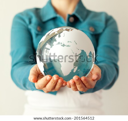 Woman holds glass earth in her hands. Globe