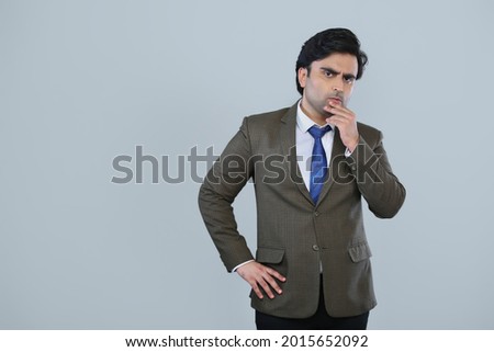 Young man in corporate suit giving expression in grey background