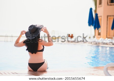At pool beach. People woman lifestyle relax and rest near luxury swimming pools sunbath at home, summer day at the resort in the hotel. Summer Concept.