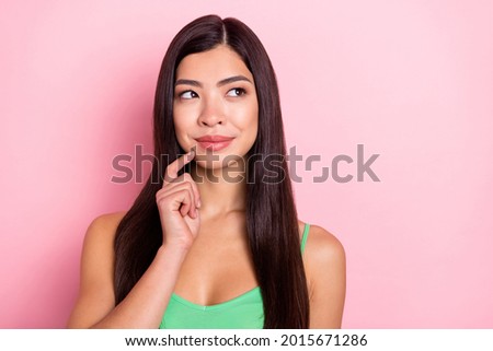 Photo of dreamy sweet young lady wear green tank-top finger chin looking empty space smiling isolated pink color background