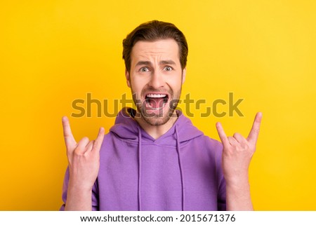 Photo of young excited man rocker music lover excited show fingers rock sign isolated over yellow color background