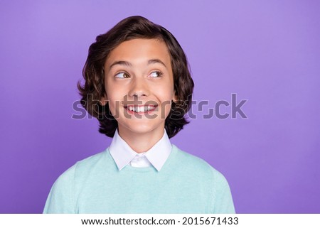 Photo of dreamy pretty school boy wear turquoise sweater smiling looking empty space isolated violet color background
