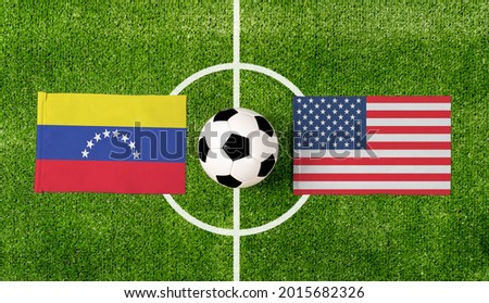 Top view soccer ball with Venezuela vs. USA flags match on green football field