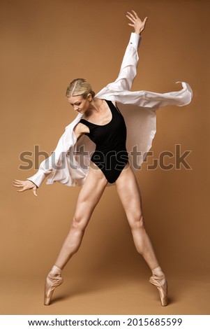 Woman Dancing Modern Jazz Ballet. Active Fit Ballerina in Dynamic Pose Pointe Shoes Tiptoe. Dancer in Motion over Brown Background