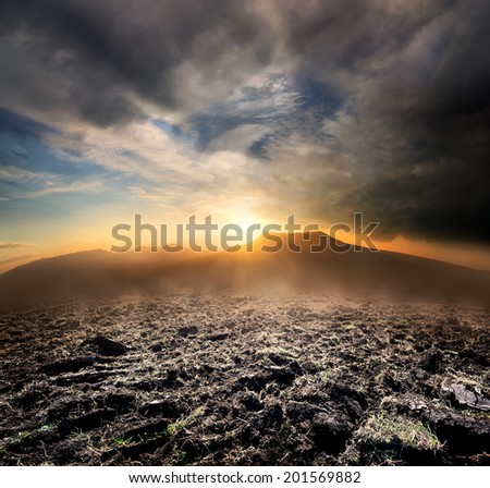 Plowed field in the mountains at sunset
