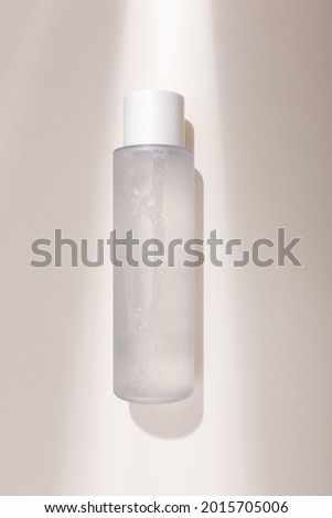 Mock up bottle of essence toner with no label in trendy natural light. Face skin care cosmetics, moisturizer, copy space Royalty-Free Stock Photo #2015705006