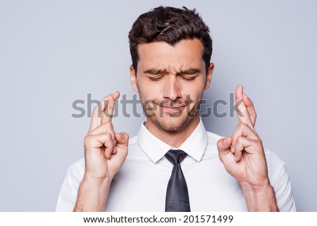 Confident handsome. Handsome young man in white shirt looking at camera and keeping arms crossed while standing against grey background Royalty-Free Stock Photo #201571499