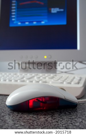 Optical computer mouse with graph on screen in the background