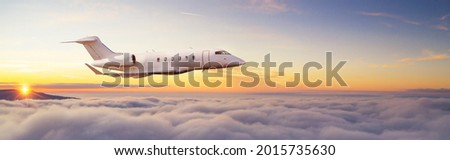 Private Passengers jetliner flying above clouds in sunset light. Concept of fast travel, holidays and business. Royalty-Free Stock Photo #2015735630