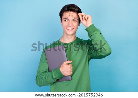 Photo portrait young guy keeping laptop wearing glasses smiling looking copyspace isolated pastel blue color background