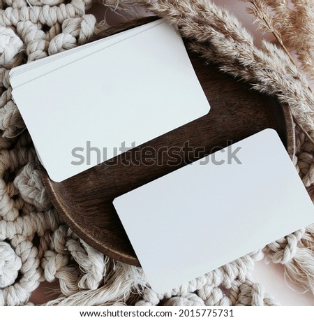 Card mockup template in Boho style  beige neutral background from makrame, dry grass, wooden.Top view.Copy space.
