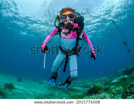 Teaching a child to dive underwater in scuba gear