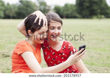 Two teenage sisters taking photo with the phone