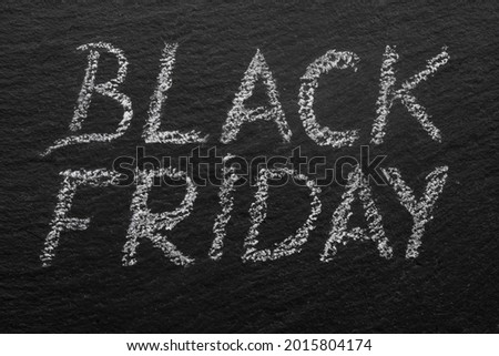black friday written with chalk on a black stone tile, macro texture