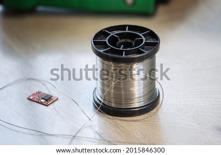 The solder for soldering is wound on a coil. Royalty-Free Stock Photo #2015846300
