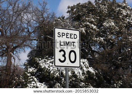 A speed limit sign frozen in ice.