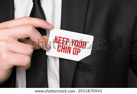 Businessman holding a card with text Keep your chin up