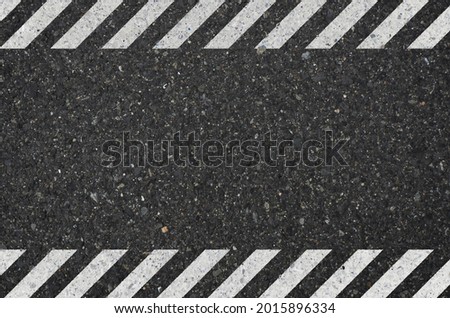 Asphalt texture with hazard sign. White hazard pattern on asphalt background